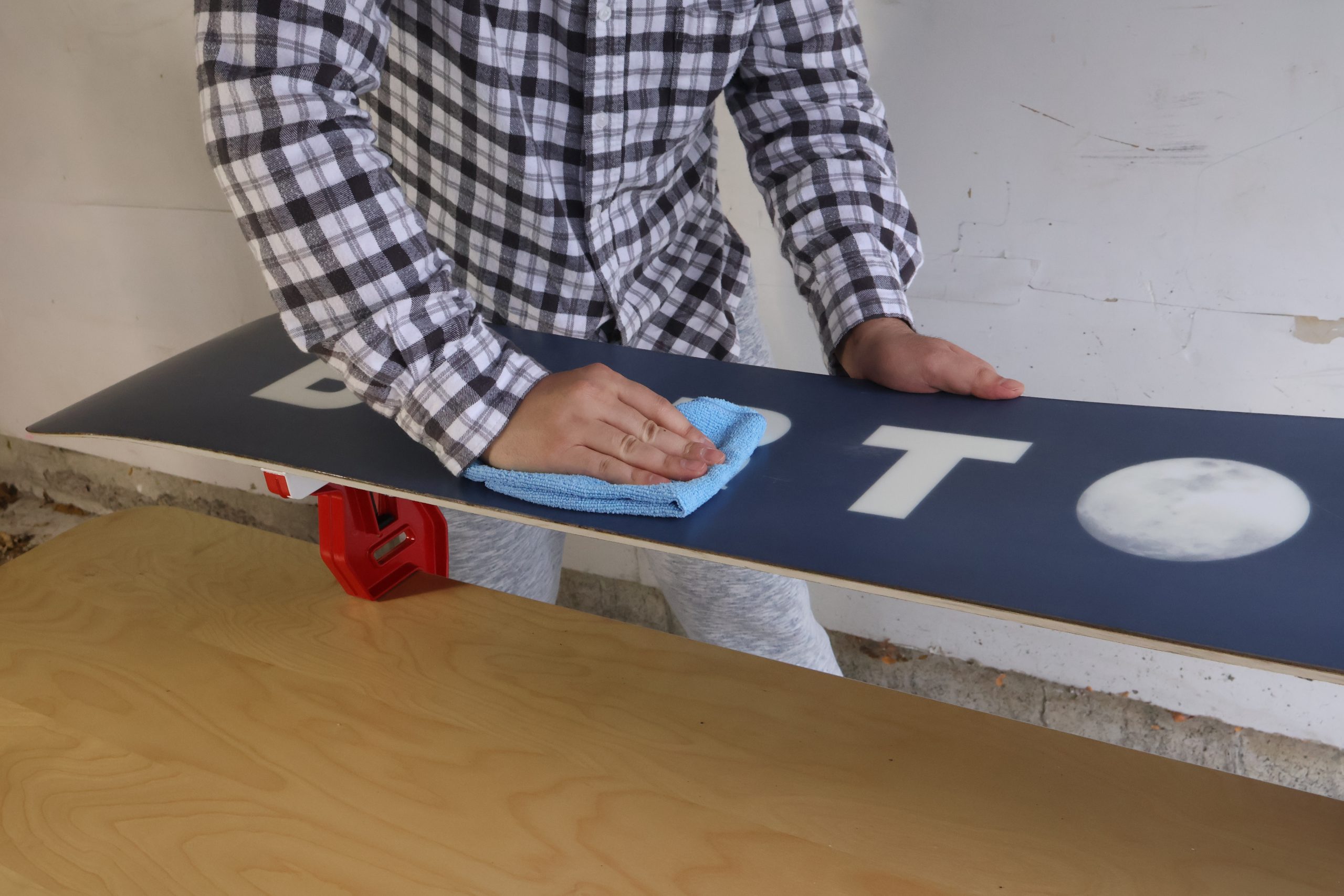 wiping snowboard clean with microfiber cloth